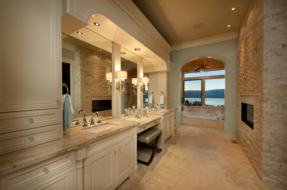 Ejemplo de cuarto de baño tradicional con armarios con paneles empotrados, puertas de armario beige, bañera encastrada, baldosas y/o azulejos beige, ventanas y piedra