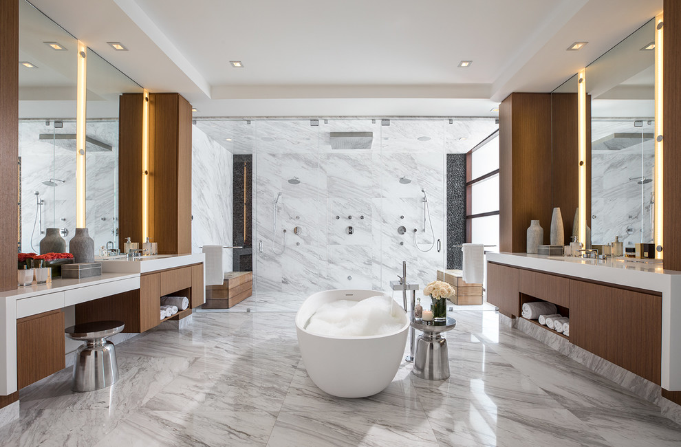 Inredning av ett modernt mycket stort vit vitt en-suite badrum, med släta luckor, bruna skåp, ett fristående badkar, en öppen dusch, vit kakel, marmorkakel, vita väggar, marmorgolv, ett integrerad handfat, bänkskiva i kvarts och vitt golv