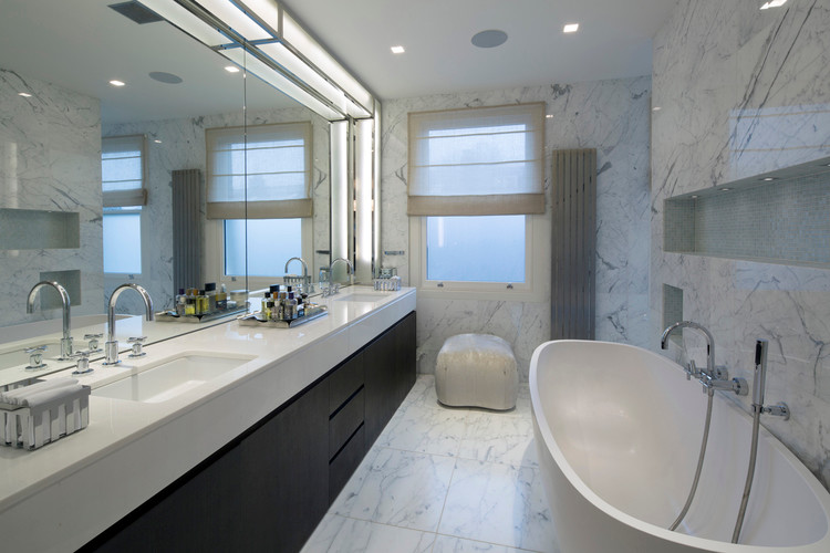 Photo of a medium sized contemporary family bathroom in London with marble worktops, a freestanding bath, stone tiles, marble flooring, dark wood cabinets, a walk-in shower, white tiles and white walls.