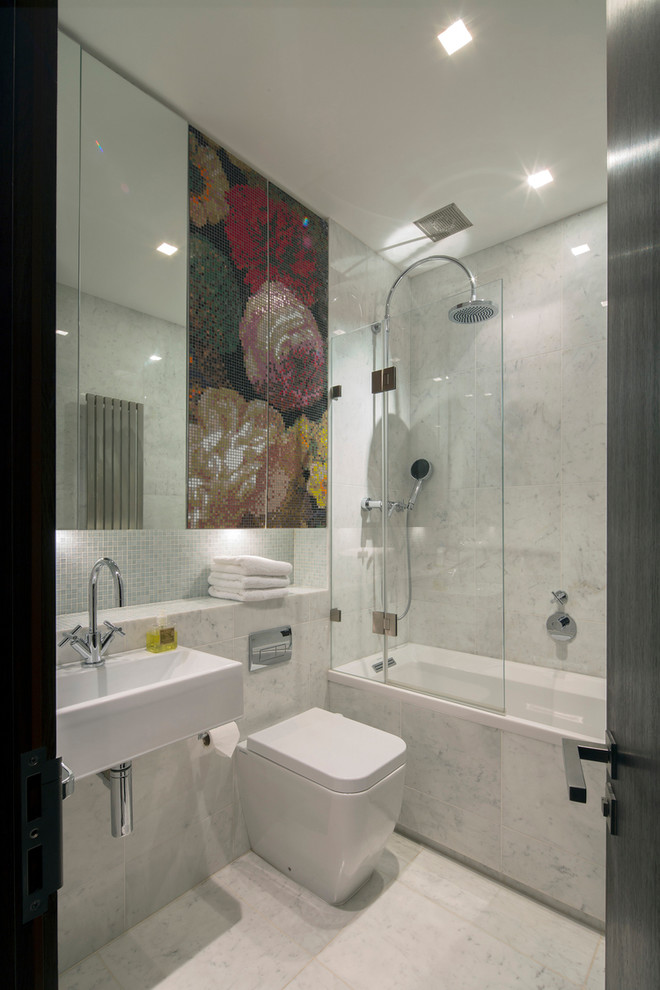 Пример оригинального дизайна: ванная комната среднего размера в современном стиле с подвесной раковиной, мраморной столешницей, накладной ванной, душем над ванной, каменной плиткой, мраморным полом, белой плиткой, белыми стенами, душевой кабиной и унитазом-моноблоком