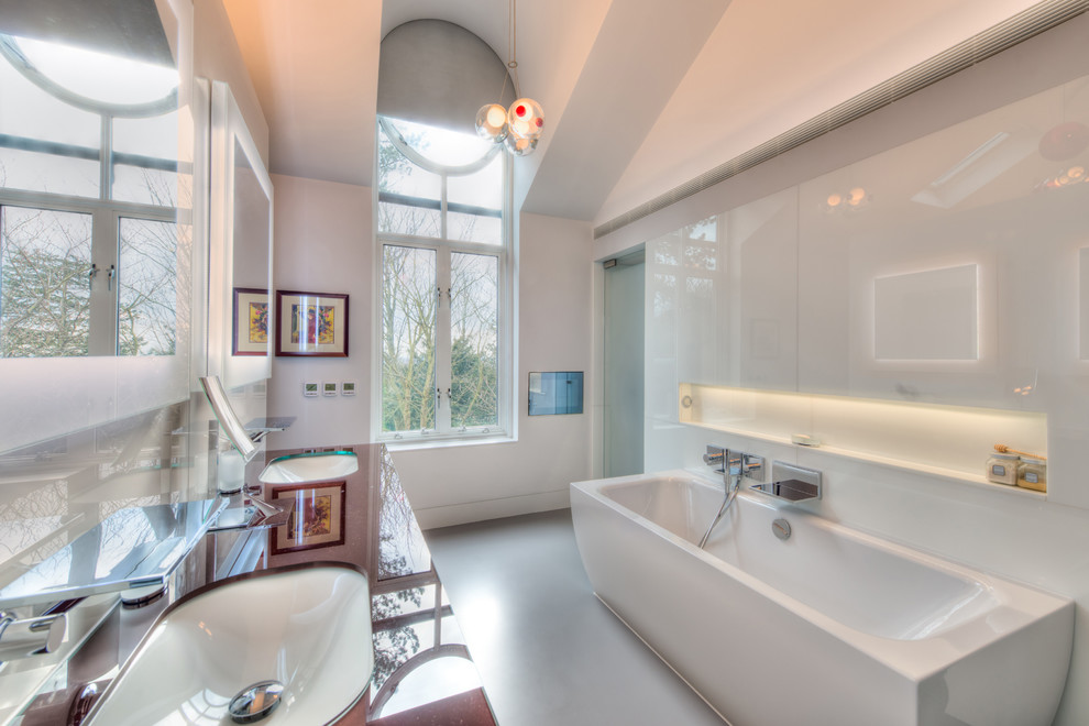 Imagen de cuarto de baño principal contemporáneo con lavabo bajoencimera, bañera exenta, paredes blancas y ventanas
