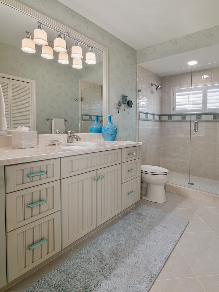 Inspiration for a small coastal kids' beige tile and ceramic tile ceramic tile alcove shower remodel in Miami with an undermount sink, shaker cabinets, light wood cabinets, granite countertops, a two-piece toilet and multicolored walls