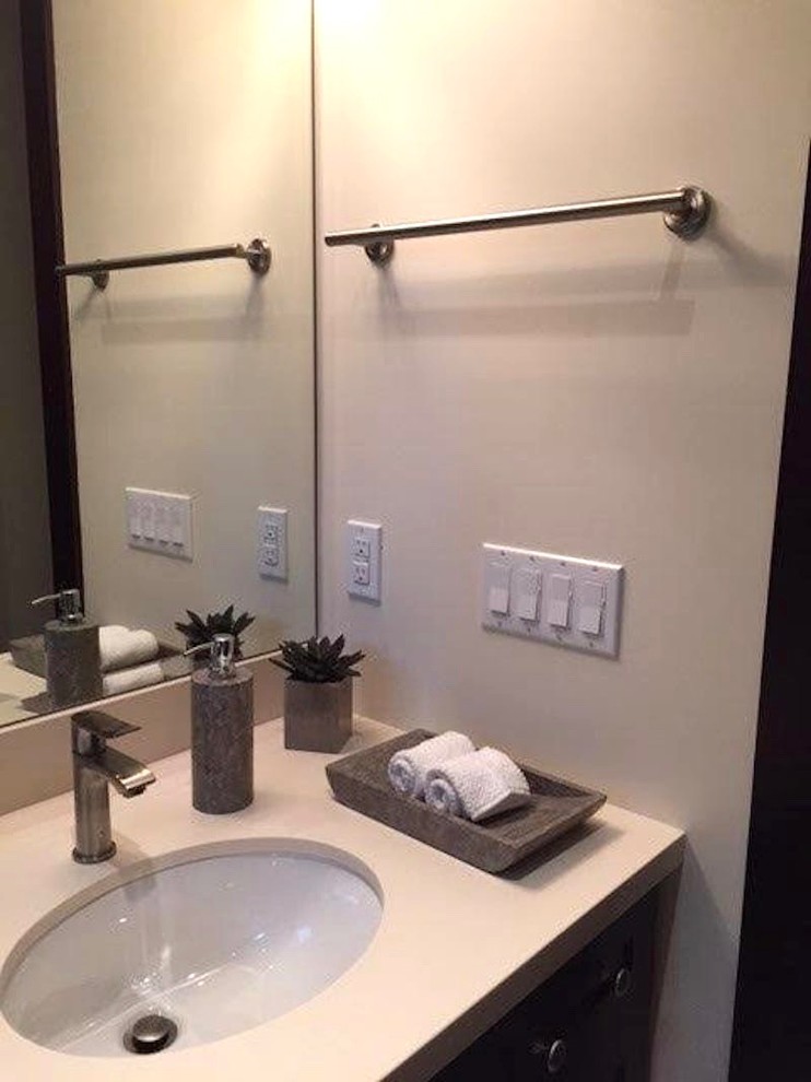 Modelo de cuarto de baño tradicional renovado pequeño con puertas de armario de madera en tonos medios, sanitario de una pieza, paredes beige, aseo y ducha, lavabo bajoencimera y encimera de cuarcita