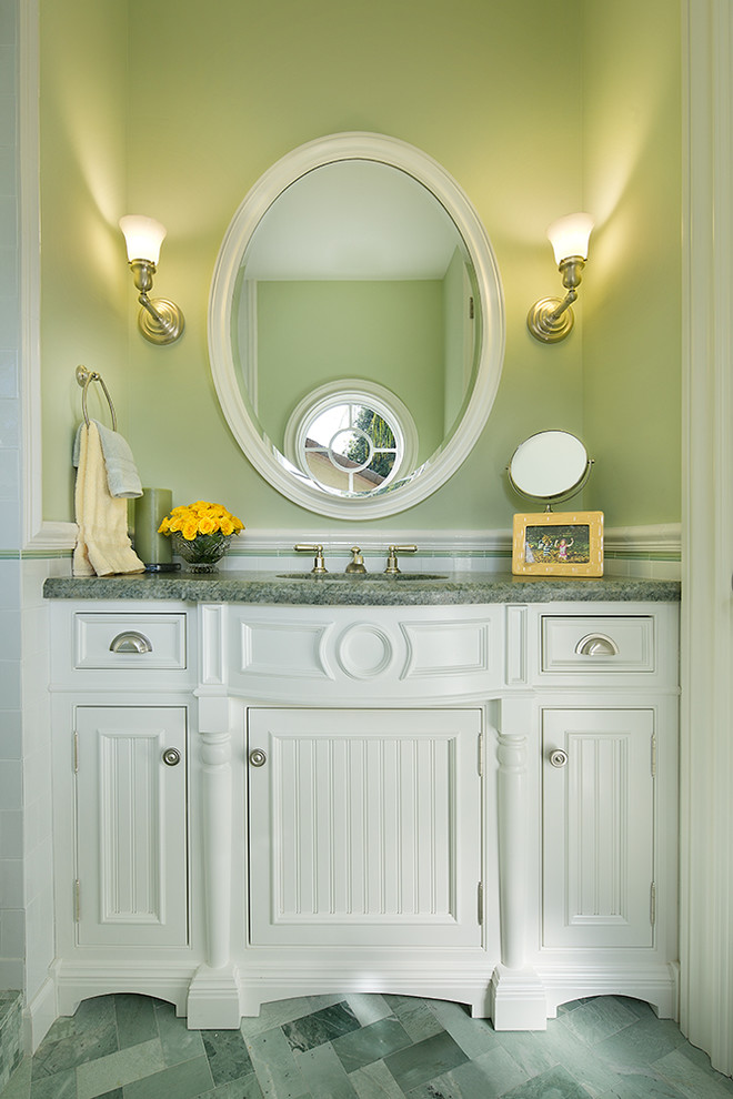 Klassisk inredning av ett mellanstort grön grönt badrum, med ett undermonterad handfat, möbel-liknande, vita skåp, marmorbänkskiva, en dusch i en alkov, en toalettstol med separat cisternkåpa, grön kakel, gröna väggar, marmorgolv, keramikplattor och grönt golv