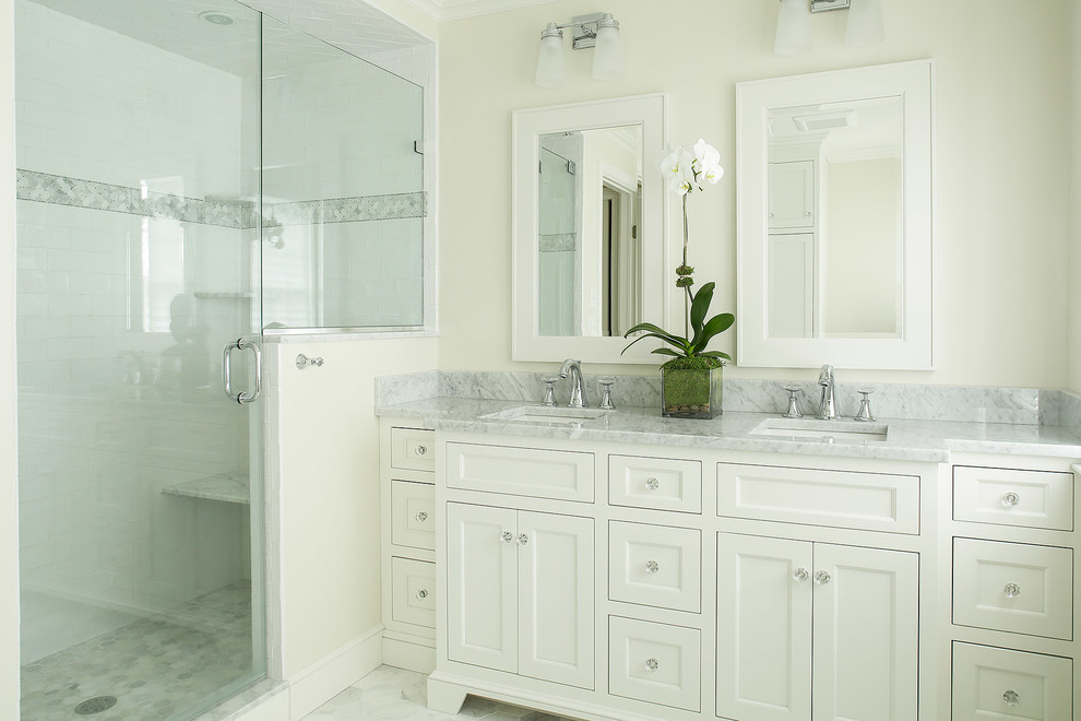 Diseño de cuarto de baño principal tradicional de tamaño medio con armarios con paneles empotrados, puertas de armario blancas, ducha esquinera y encimera de mármol
