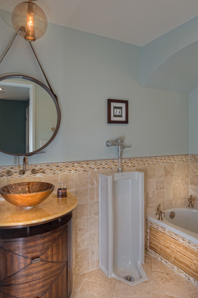Immagine di una stanza da bagno classica con lavabo a bacinella, ante in legno bruno, orinatoio, piastrelle beige e pareti blu