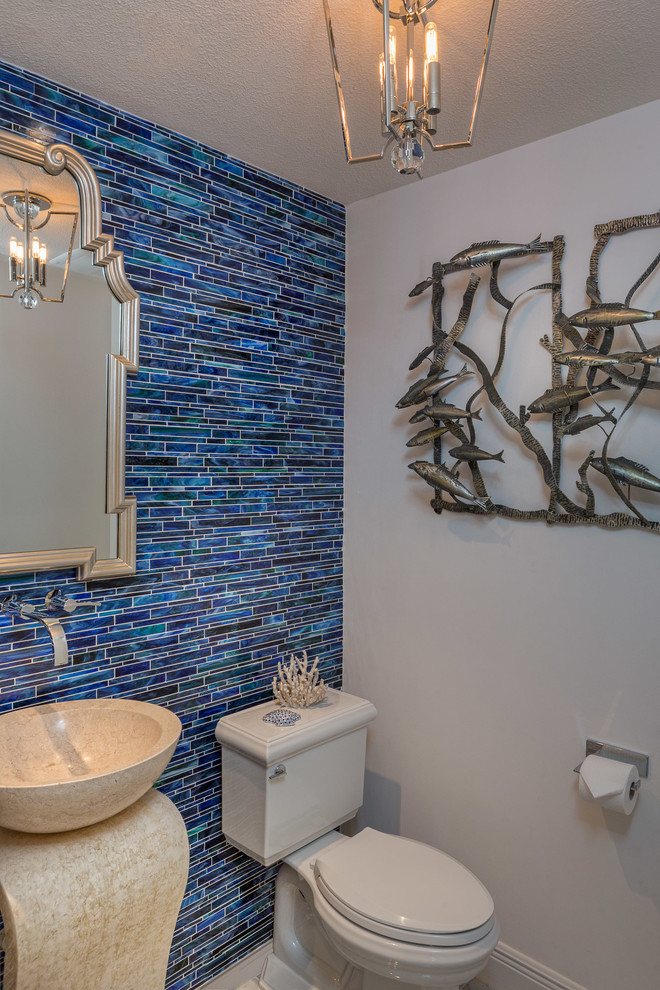 Ejemplo de cuarto de baño costero con lavabo con pedestal, sanitario de dos piezas, baldosas y/o azulejos azules, azulejos en listel y paredes azules