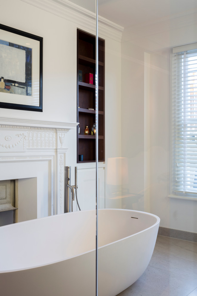 Photo of a medium sized contemporary ensuite bathroom in London with dark wood cabinets, a freestanding bath, a walk-in shower, a wall mounted toilet, beige tiles, stone slabs, white walls, marble flooring and marble worktops.