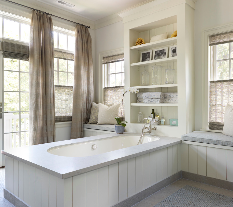 На фото: ванная комната в стиле неоклассика (современная классика) с полновстраиваемой ванной и белыми стенами с