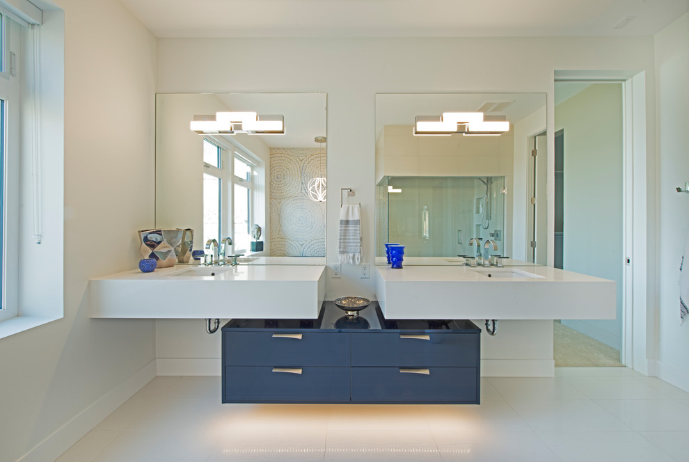 Immagine di una stanza da bagno contemporanea con ante lisce, ante blu, doccia ad angolo, lavabo sospeso, pavimento bianco e pareti bianche