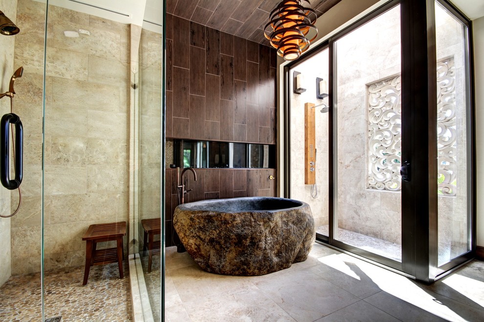 На фото: ванная комната в восточном стиле с отдельно стоящей ванной, душем в нише и коричневой плиткой с