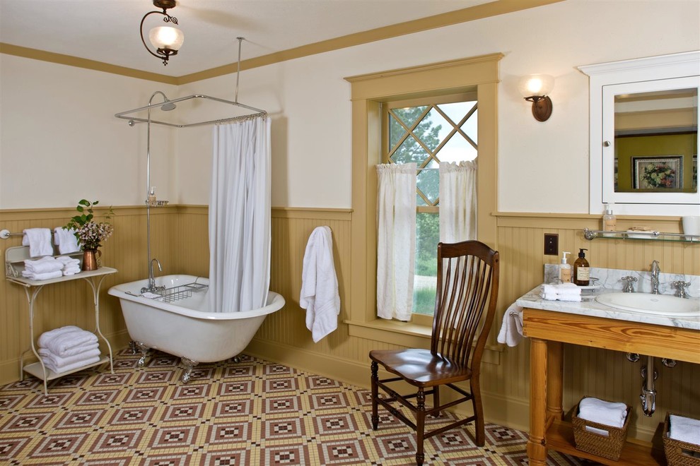 Foto di una stanza da bagno country con lavabo da incasso, vasca con piedi a zampa di leone, vasca/doccia e pavimento con piastrelle a mosaico
