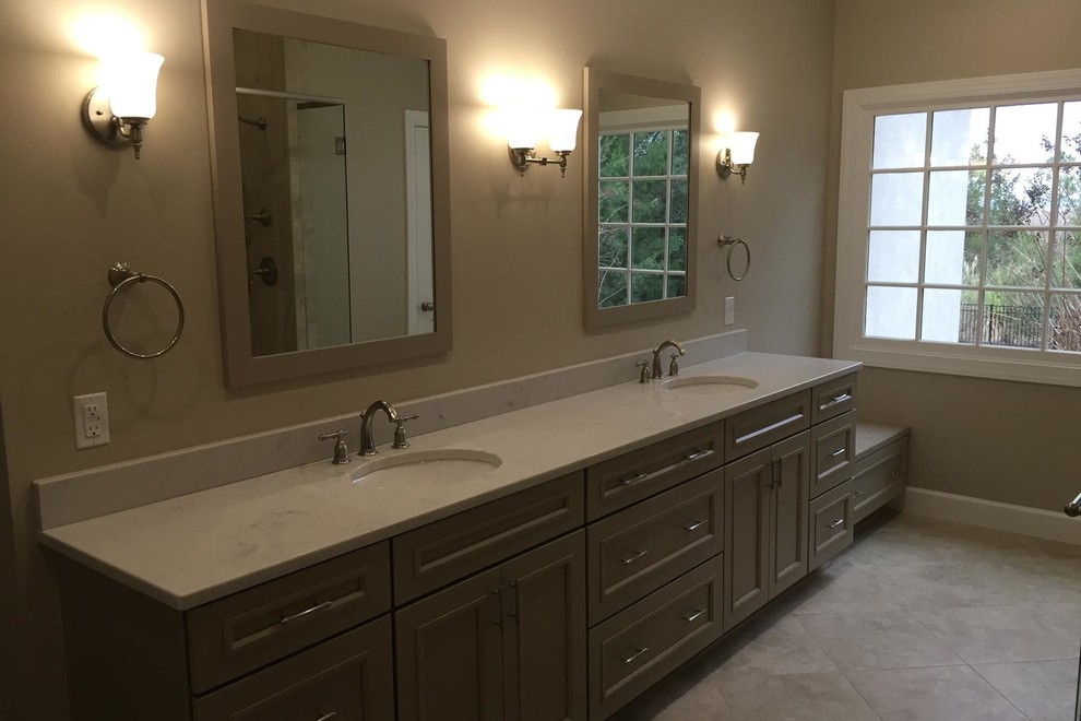 Example of a large transitional master beige tile and porcelain tile porcelain tile double shower design in Charleston with recessed-panel cabinets, a two-piece toilet, beige walls, an undermount sink, quartz countertops and gray cabinets