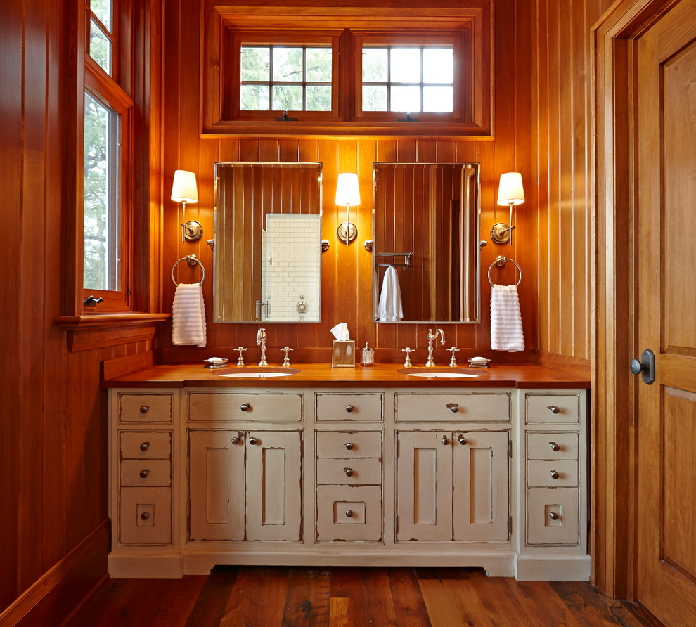 Ispirazione per una grande stanza da bagno padronale stile rurale con lavabo sottopiano, consolle stile comò, ante con finitura invecchiata, top in legno e pavimento in legno massello medio