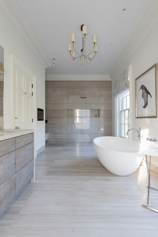 Modern inredning av ett badrum, med kakelplattor, kalkstensgolv, bänkskiva i kalksten och beiget golv