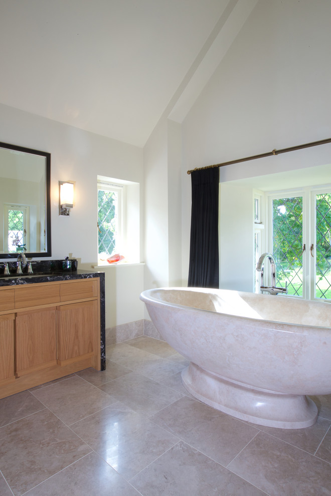 На фото: ванная комната в стиле модернизм с бежевой плиткой, полом из известняка и мраморной столешницей с
