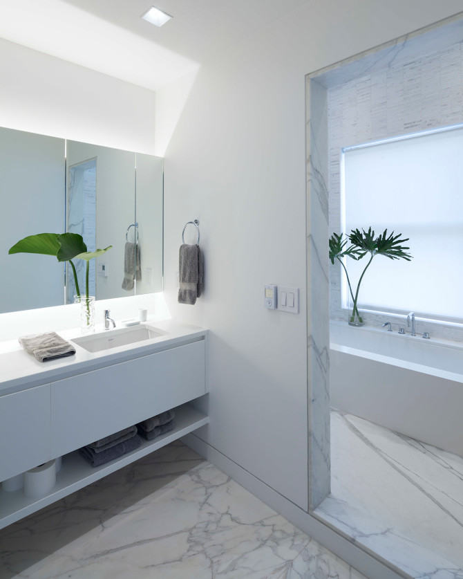 Exempel på ett stort modernt en-suite badrum, med ett väggmonterat handfat, vita skåp, ett badkar i en alkov, en dusch i en alkov, en vägghängd toalettstol, vit kakel, stenhäll, vita väggar och marmorgolv