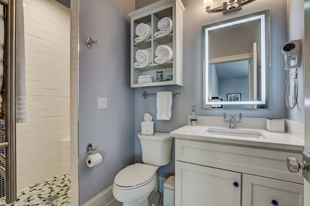Example of a large beach style 3/4 gray tile and subway tile porcelain tile and multicolored floor bathroom design in Milwaukee with flat-panel cabinets, white cabinets, a two-piece toilet, gray walls, an undermount sink, quartz countertops, a hinged shower door and white countertops
