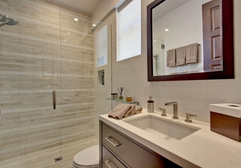 Walk-in shower - mid-sized transitional 3/4 beige tile and stone tile limestone floor walk-in shower idea in Other with an undermount sink, furniture-like cabinets, dark wood cabinets, limestone countertops, a one-piece toilet and beige walls