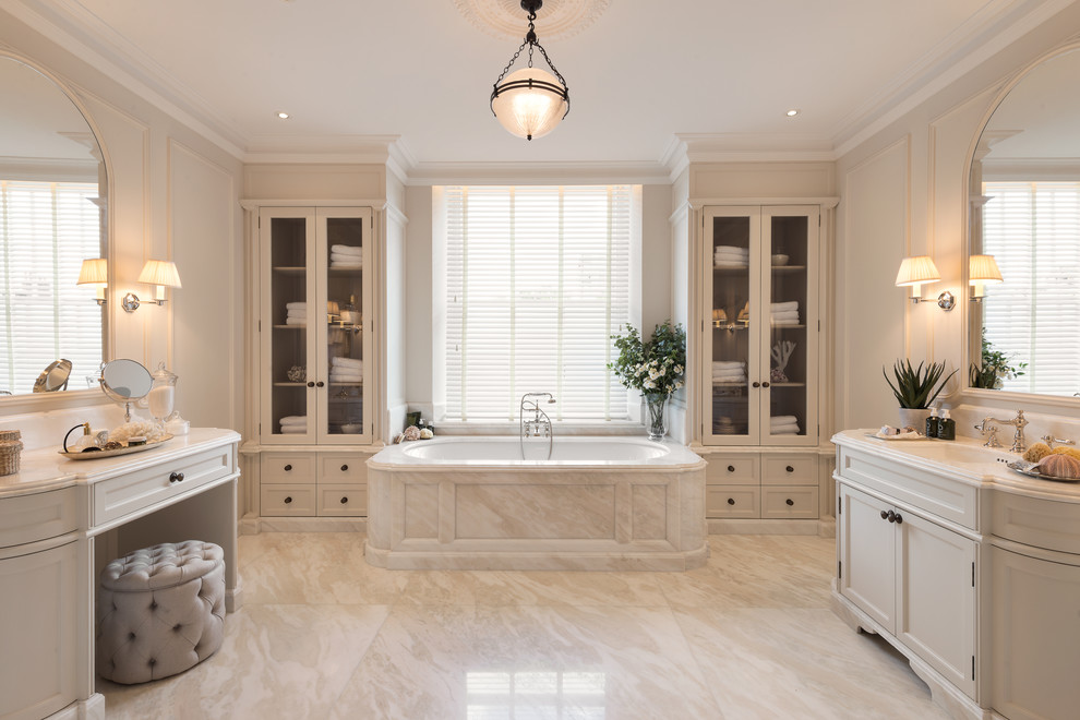 Aménagement d'une salle de bain principale contemporaine avec une baignoire posée, un mur blanc, un sol en marbre, un lavabo posé, un plan de toilette en marbre, un sol blanc et un plan de toilette blanc.