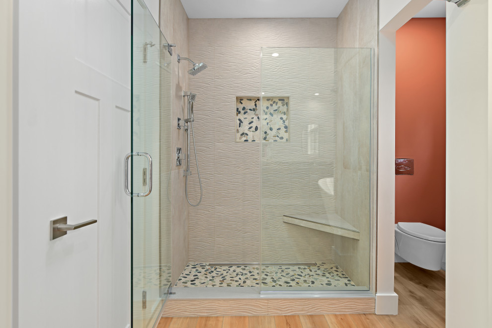 Inspiration för ett stort funkis grå grått en-suite badrum, med släta luckor, skåp i mellenmörkt trä, ett fristående badkar, en dusch i en alkov, en vägghängd toalettstol, beige kakel, porslinskakel, beige väggar, klinkergolv i småsten, ett undermonterad handfat, granitbänkskiva, flerfärgat golv och dusch med gångjärnsdörr