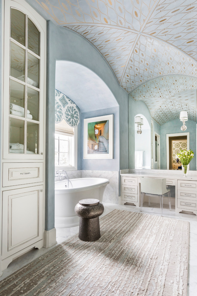 Inspiration for a transitional white floor freestanding bathtub remodel in Houston with raised-panel cabinets, white cabinets and blue walls