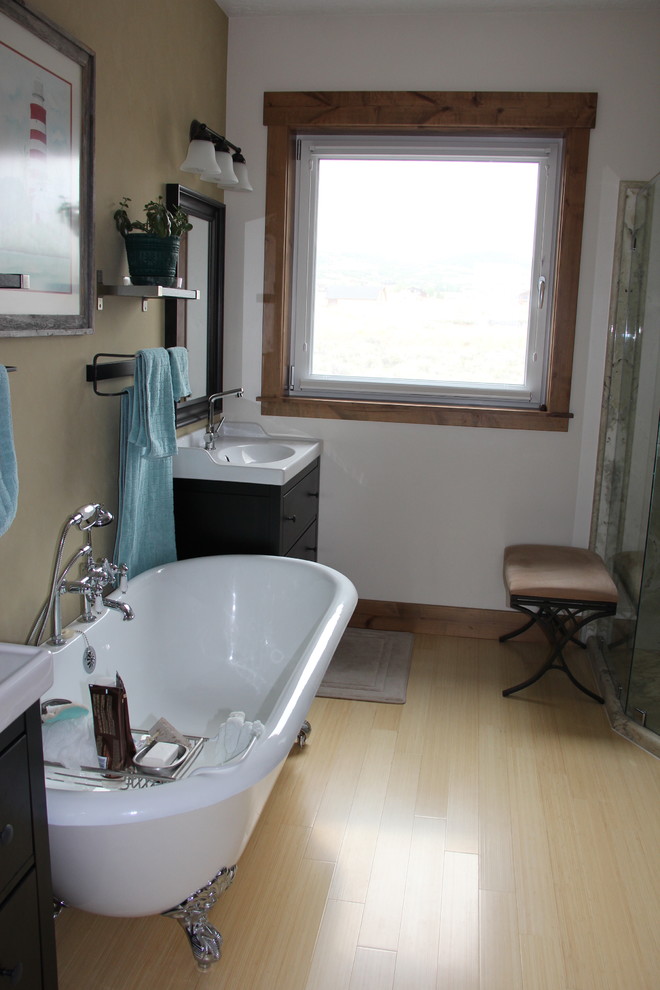 Imagen de cuarto de baño principal de estilo de casa de campo de tamaño medio con lavabo con pedestal, puertas de armario de madera en tonos medios, bañera con patas, ducha esquinera, sanitario de una pieza, paredes marrones y suelo de bambú