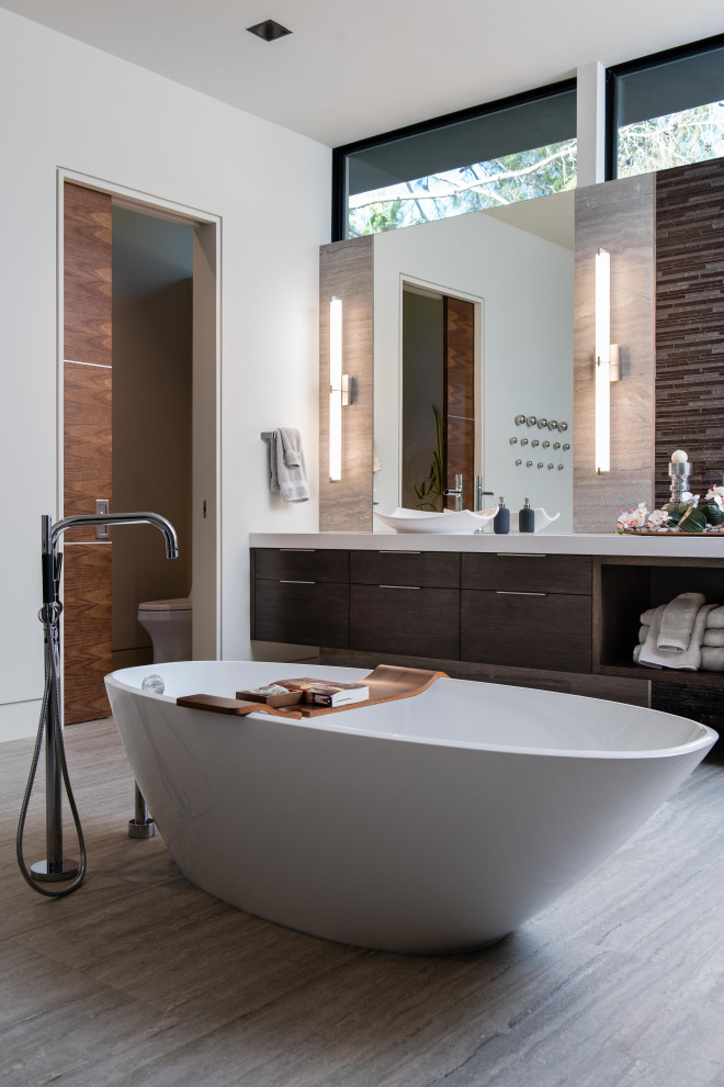 This is an example of an expansive contemporary ensuite bathroom in Las Vegas with flat-panel cabinets, dark wood cabinets, a hot tub, a one-piece toilet, white walls, porcelain flooring, a vessel sink, grey floors, white worktops, double sinks and a floating vanity unit.