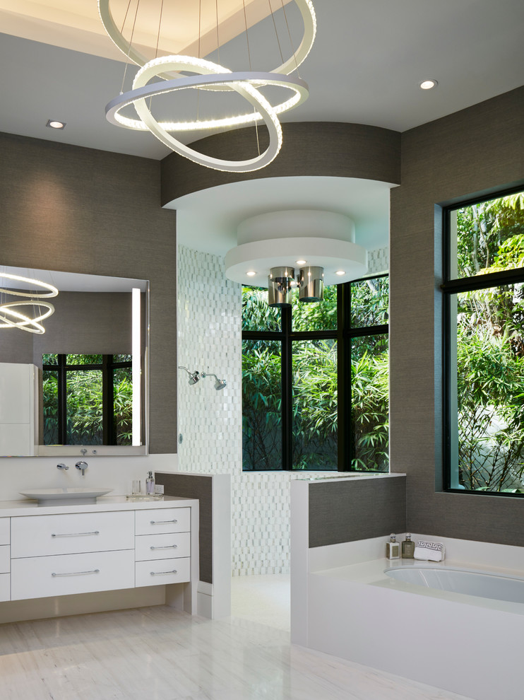 Large trendy master multicolored floor bathroom photo in Miami with flat-panel cabinets, white cabinets, an undermount tub, gray walls, a vessel sink and solid surface countertops