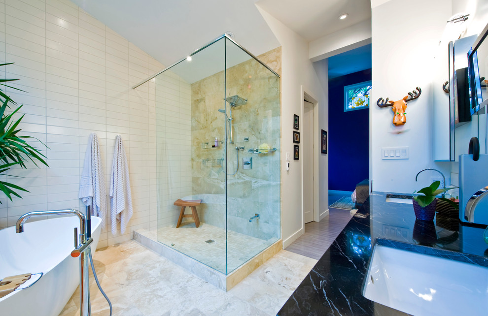 Cette image montre une salle de bain design avec une baignoire indépendante, une douche ouverte et aucune cabine.