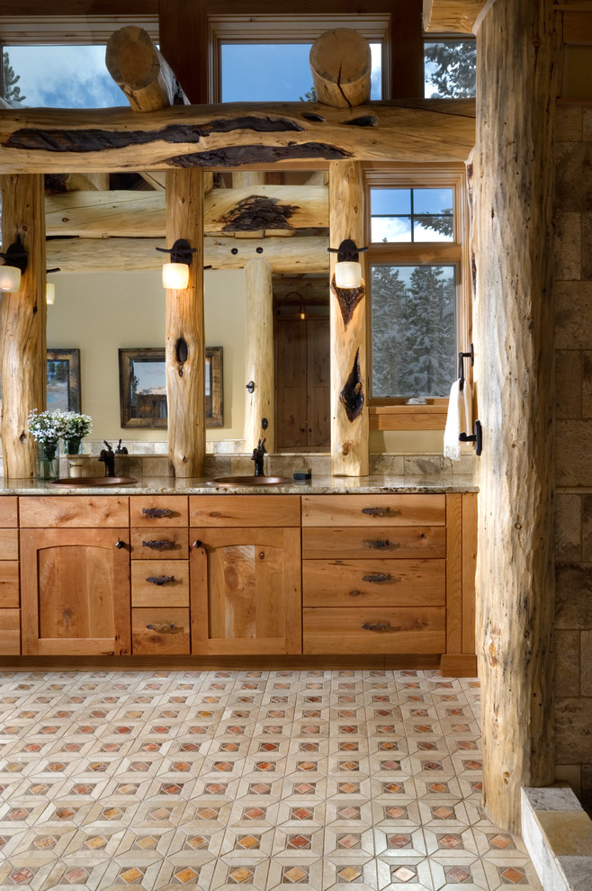 Идея дизайна: ванная комната в деревянном доме в стиле рустика с накладной раковиной, фасадами с утопленной филенкой, фасадами цвета дерева среднего тона, столешницей из гранита, разноцветной плиткой и каменной плиткой