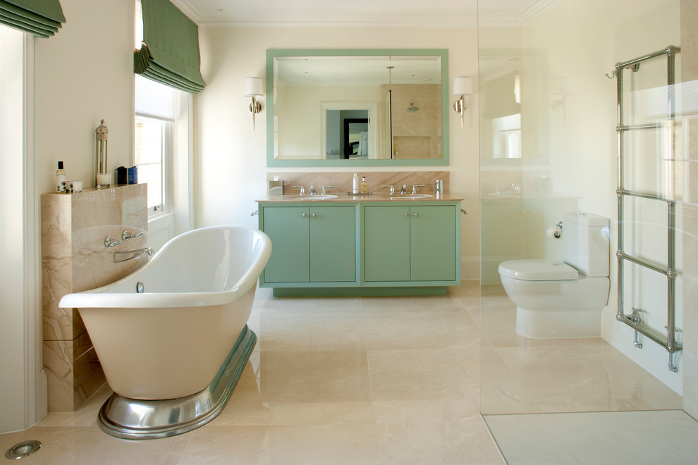 Ejemplo de cuarto de baño tradicional con bañera exenta, armarios con paneles lisos, puertas de armario verdes y suelo beige