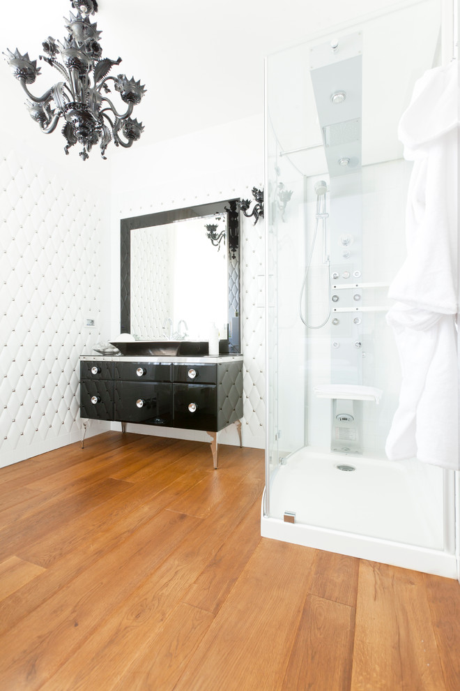 This is an example of a contemporary bathroom in Turin with a vessel sink, freestanding cabinets, dark wood cabinets, a corner shower, white tiles, white walls and medium hardwood flooring.