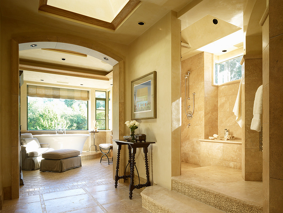 На фото: ванная комната в средиземноморском стиле с отдельно стоящей ванной и бежевыми стенами