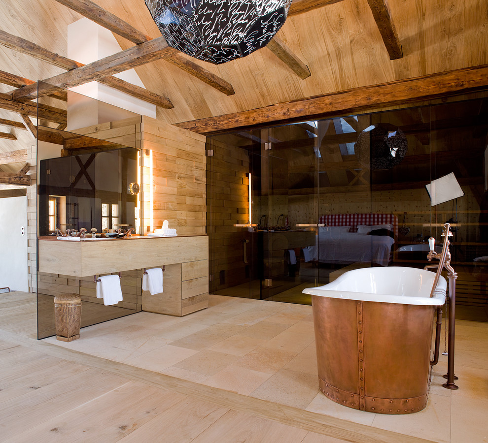 Ejemplo de cuarto de baño rural de tamaño medio con bañera exenta, baldosas y/o azulejos beige, azulejos en listel y encimera de madera