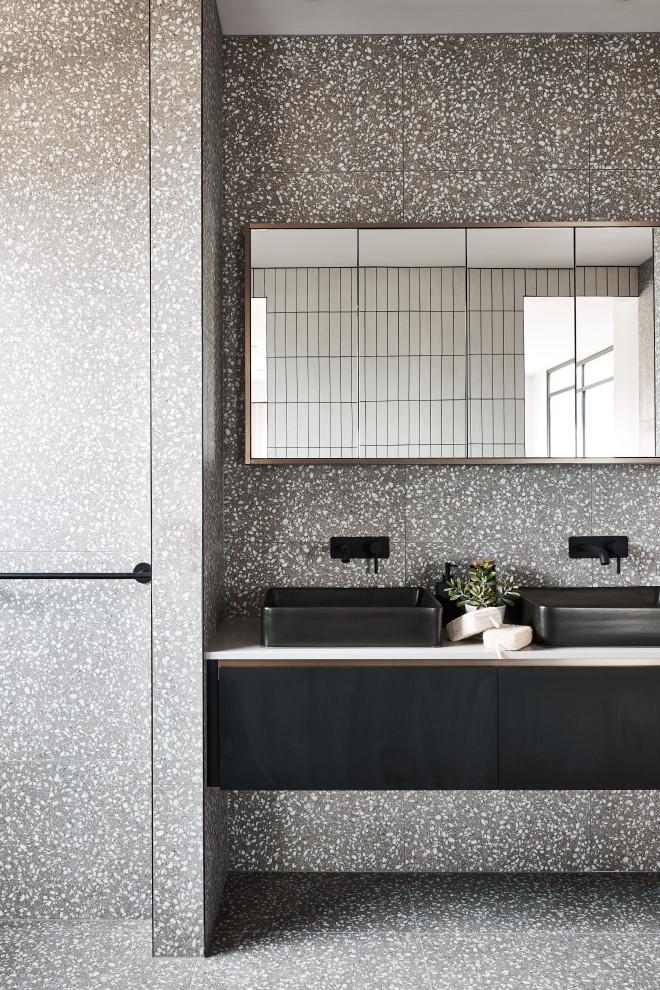 Modernes Badezimmer mit flächenbündigen Schrankfronten, schwarzen Schränken, offener Dusche, grauen Fliesen, weißen Fliesen, Terrazzo-Boden, Aufsatzwaschbecken, Mineralwerkstoff-Waschtisch, grauem Boden, offener Dusche und weißer Waschtischplatte in Melbourne
