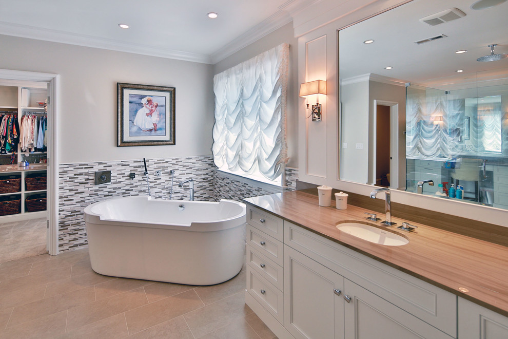 Exempel på ett klassiskt en-suite badrum, med ett undermonterad handfat, luckor med infälld panel, vita skåp, ett fristående badkar, en öppen dusch, beige kakel och grå väggar
