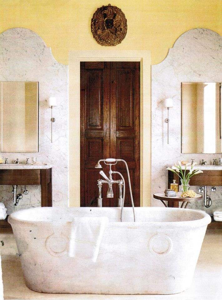 На фото: главная ванная комната среднего размера в средиземноморском стиле с открытыми фасадами, темными деревянными фасадами, отдельно стоящей ванной, серой плиткой, белой плиткой, каменной плиткой, желтыми стенами, бетонным полом и столешницей из талькохлорита с