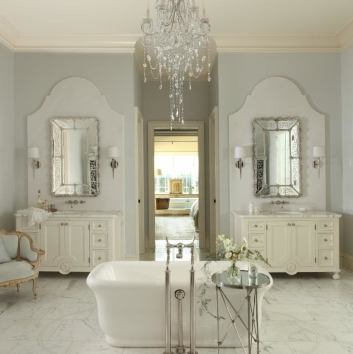 Idée de décoration pour une salle de bain principale style shabby chic de taille moyenne avec un placard en trompe-l'oeil, des portes de placard blanches, une baignoire indépendante, un mur gris, un sol en marbre, un plan de toilette en marbre, un lavabo encastré et un sol gris.