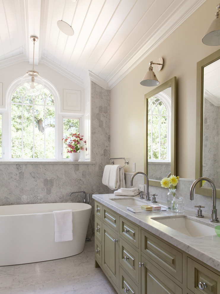 サンフランシスコにあるトラディショナルスタイルのおしゃれな浴室 (アンダーカウンター洗面器、レイズドパネル扉のキャビネット、緑のキャビネット、置き型浴槽、白いタイル、ベージュの壁) の写真