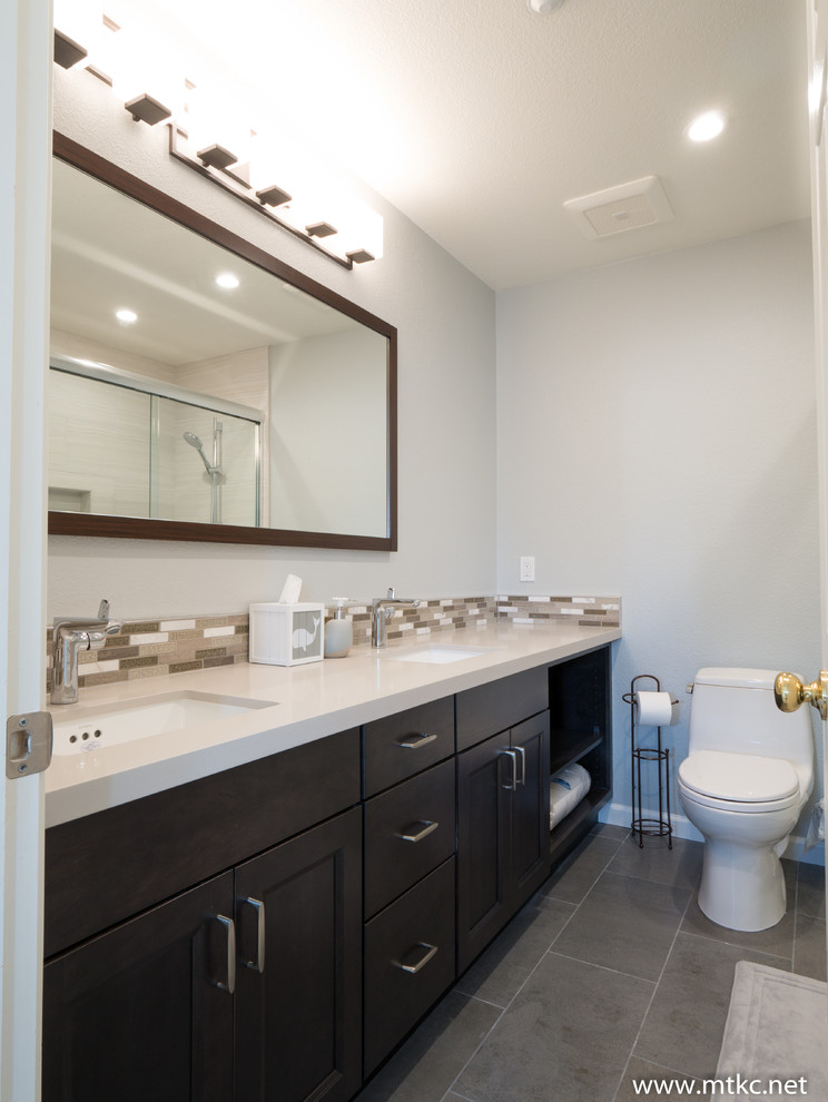 Modelo de cuarto de baño actual con armarios con paneles empotrados, puertas de armario de madera en tonos medios, encimera de cuarzo compacto y encimeras beige