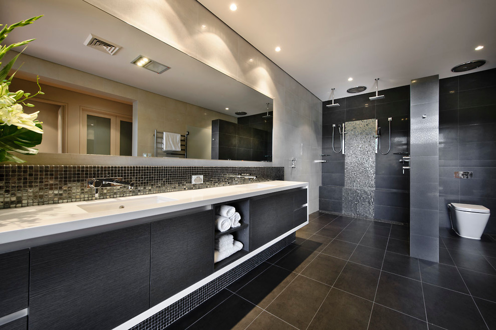 Idée de décoration pour une salle de bain design en bois foncé avec un placard à porte plane, une douche double, un carrelage noir et un mur beige.