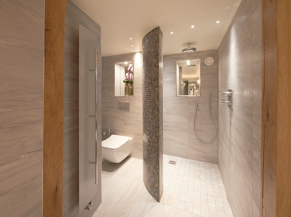 Foto di una stanza da bagno design di medie dimensioni con doccia aperta, WC sospeso, pareti grigie, pavimento bianco e doccia aperta