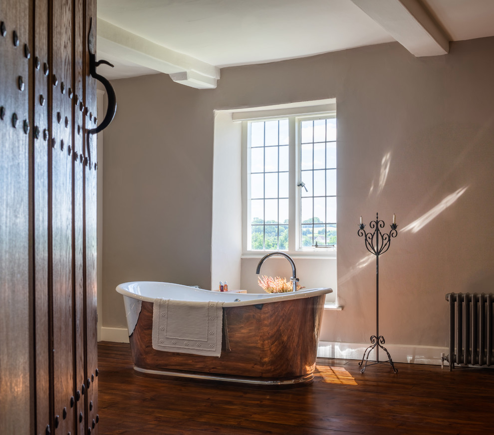 Inspiration for a bathroom in Wiltshire with a freestanding bath, dark hardwood flooring and brown floors.
