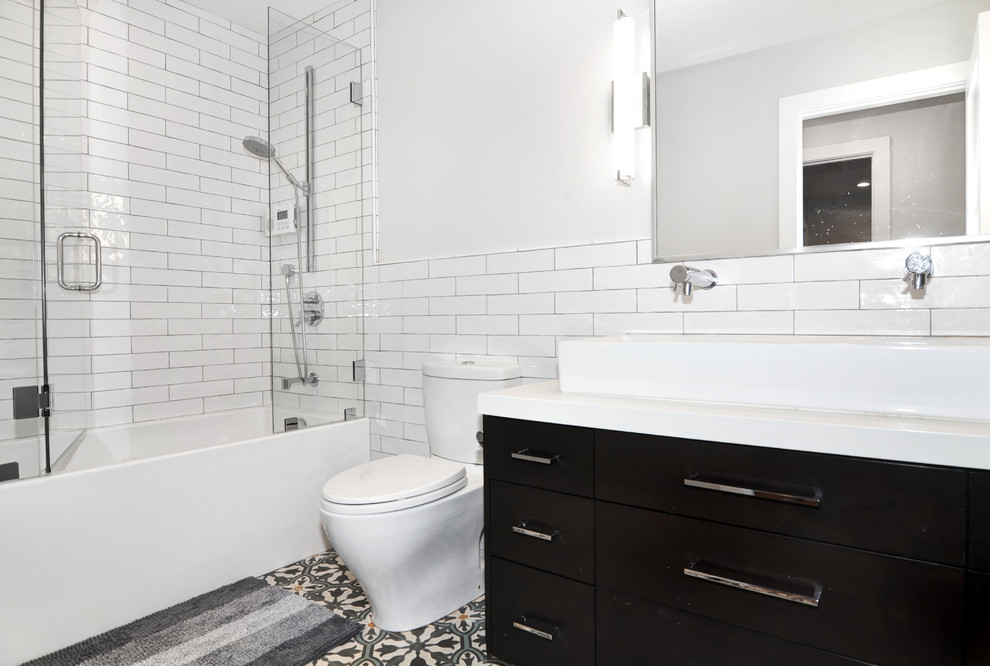 Bathroom - mid-sized contemporary 3/4 white tile cement tile floor and gray floor bathroom idea in Orange County with furniture-like cabinets, black cabinets, a one-piece toilet, white walls, a trough sink, quartz countertops, a hinged shower door and white countertops