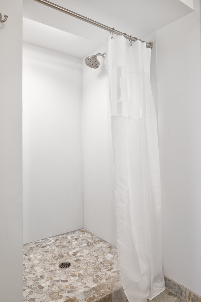 Пример оригинального дизайна: ванная комната среднего размера в стиле неоклассика (современная классика) с фасадами с выступающей филенкой, фасадами цвета дерева среднего тона, душем в нише, унитазом-моноблоком, белыми стенами, полом из галечной плитки, душевой кабиной, монолитной раковиной, мраморной столешницей, разноцветным полом, шторкой для ванной и белой столешницей