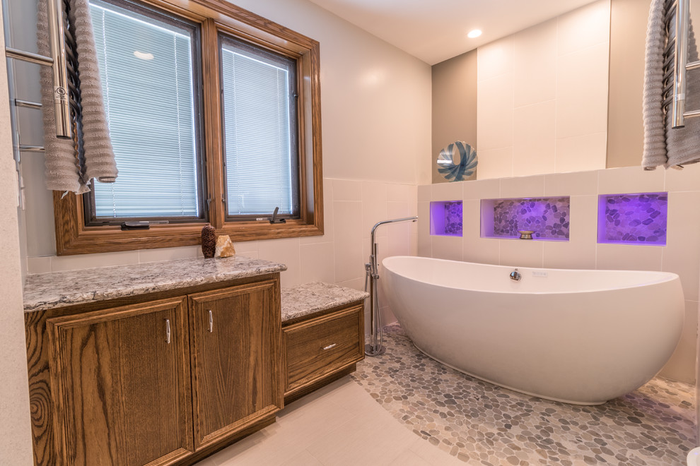 Example of a large transitional master beige tile and ceramic tile porcelain tile and multicolored floor bathroom design in Minneapolis with a one-piece toilet, gray walls, an undermount sink, quartz countertops, a hinged shower door and beige countertops