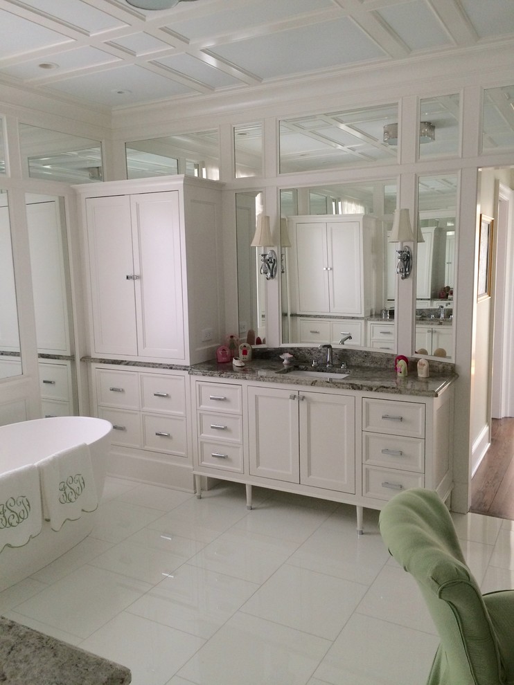 Idéer för att renovera ett stort funkis en-suite badrum, med luckor med infälld panel, vita skåp, ett fristående badkar, spegel istället för kakel, vita väggar, marmorgolv, ett undermonterad handfat, granitbänkskiva och vitt golv