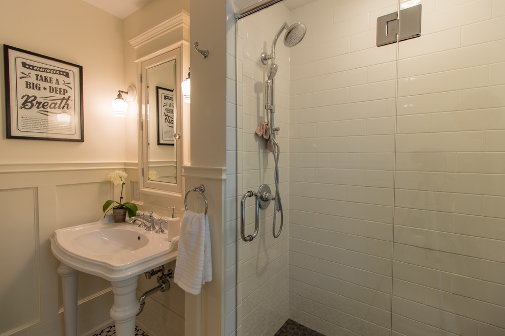 ミネアポリスにあるトラディショナルスタイルのおしゃれなマスターバスルーム (アルコーブ型シャワー、一体型トイレ	、白いタイル、サブウェイタイル、白い壁、セメントタイルの床、コンソール型シンク、開き戸のシャワー) の写真