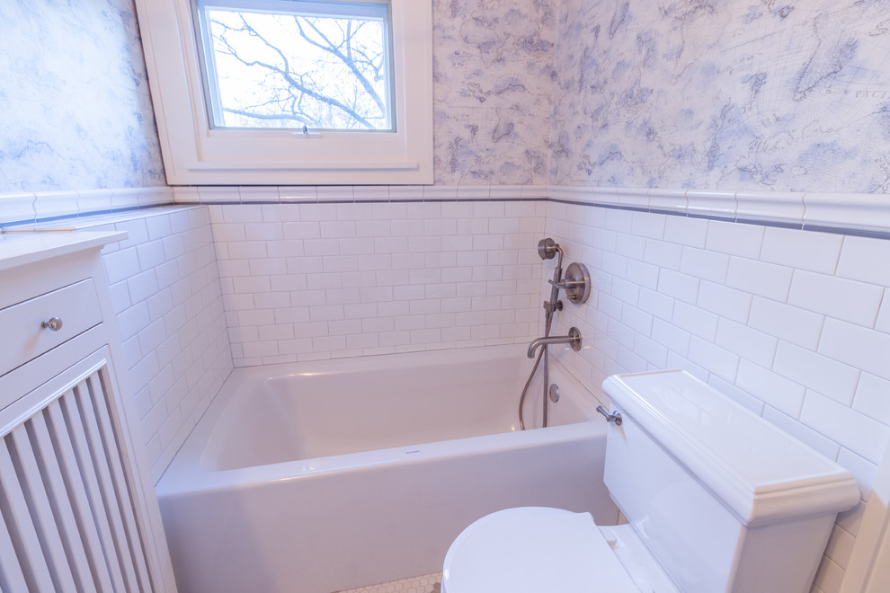 Cette image montre une salle de bain traditionnelle de taille moyenne pour enfant avec une baignoire en alcôve, WC à poser, un carrelage blanc, un carrelage métro, un mur multicolore et un lavabo de ferme.